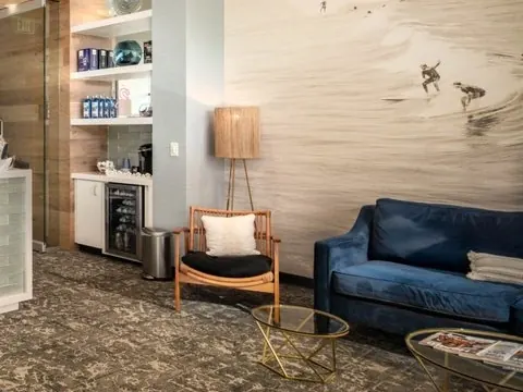 The lounge at Golden Hills Family Dental, with a blue sofa and a surf mural.